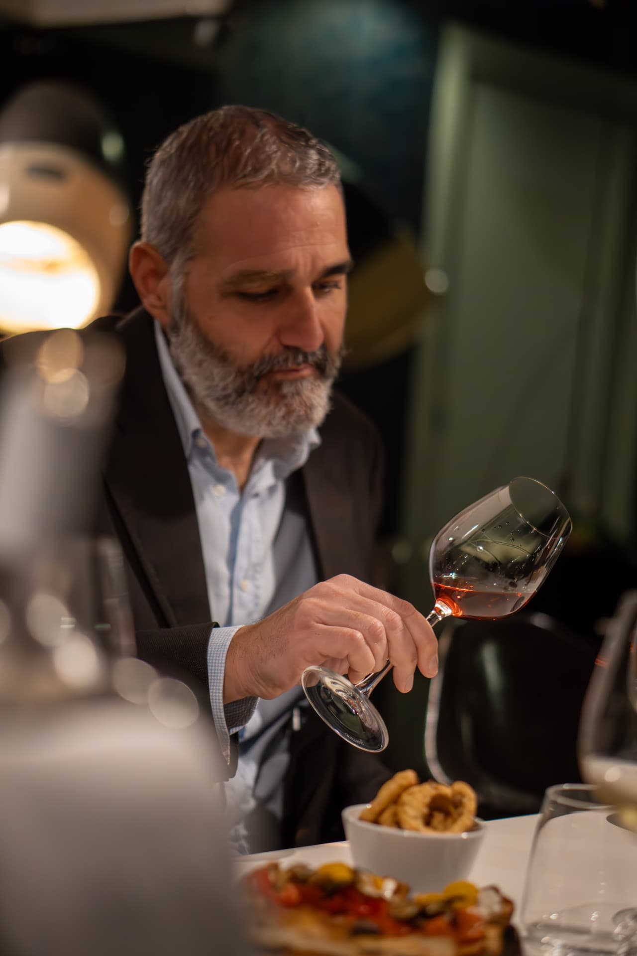 Ospite osserva il calice durante la degustazione